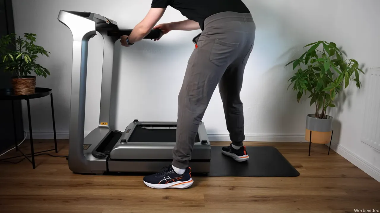 WalkingPad X218 eingeklappt zum Verschieben, Person kippt Laufband an den Griffen