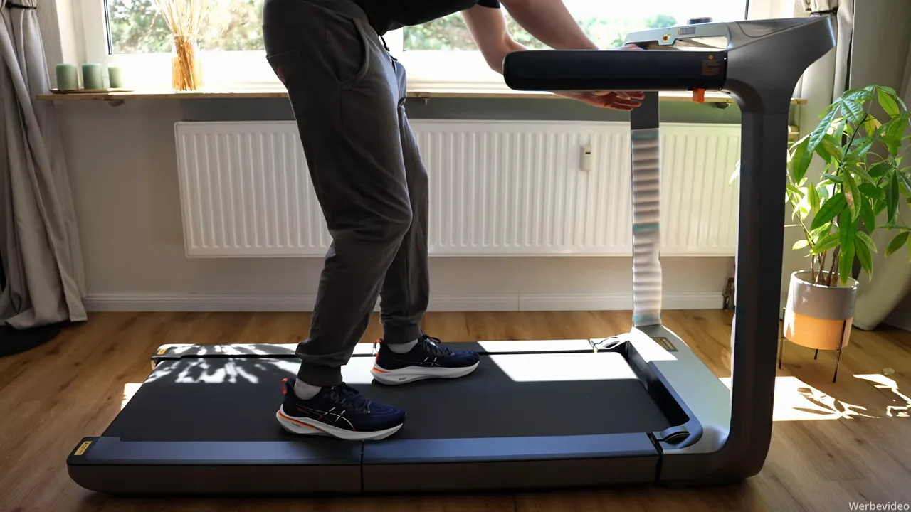 Person löst den orangen Entriegelungshebel am WalkingPad X218 beim Zusammenklappen