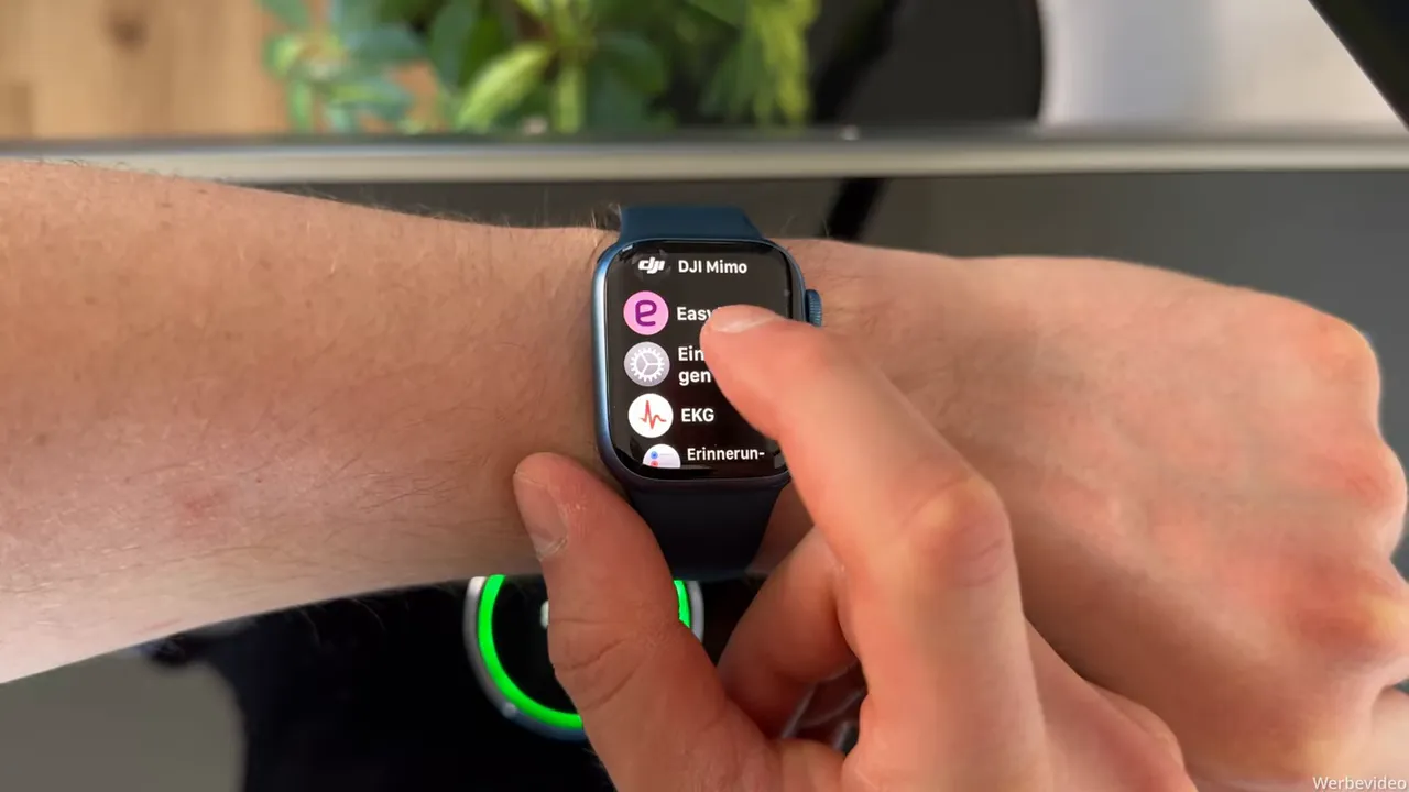 Apple Watch zeigt Apps-Liste, Finger scrollt und wählt eine App aus (App‑Auswahl für Kopplung)