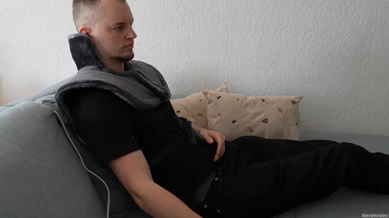 Heizdecke für Rücken, Schulter & Nacken von Bob & Brad im Test 10 Person entspannt auf dem Sofa mit einer beheizten Nacken- und Rückenheizdecke