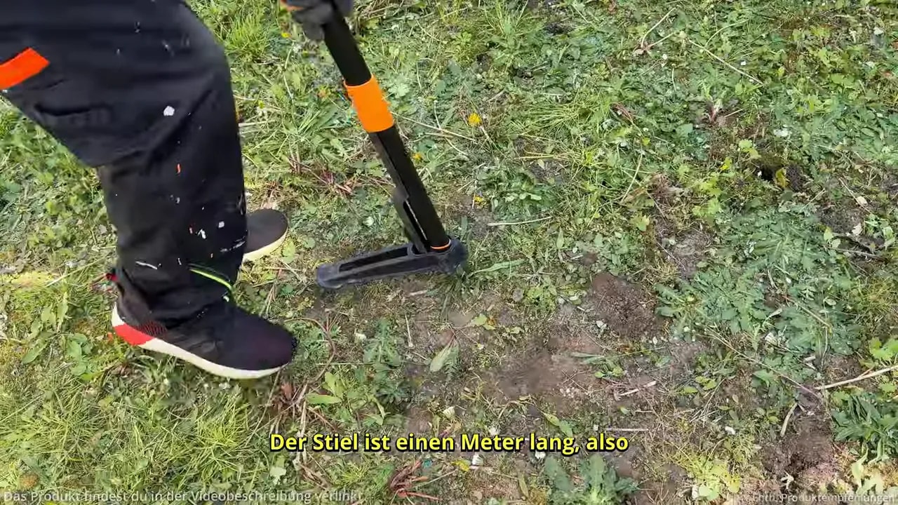 Fußpedal und langer Stiel des Fiskars X-Act Unkrautstechers im Einsatz