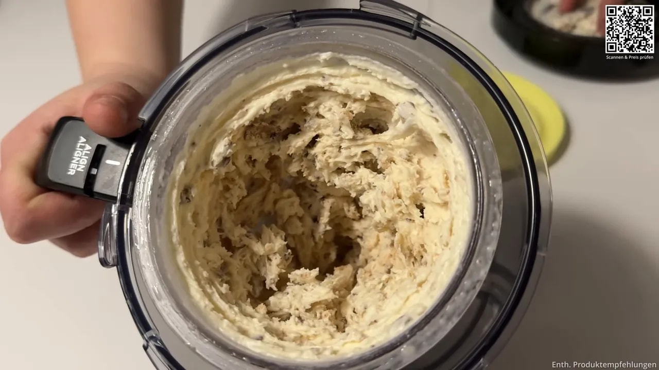 Nahaufnahme von cremigem Eis mit kleinen dunklen Einsprengseln im Behälter