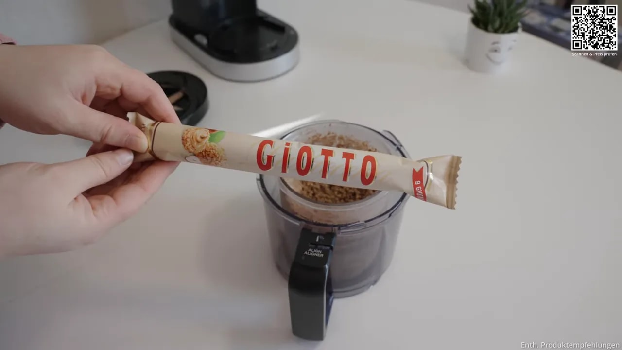 Hand hält eine geöffnete Giotto-Packung über einem Eisbehälter