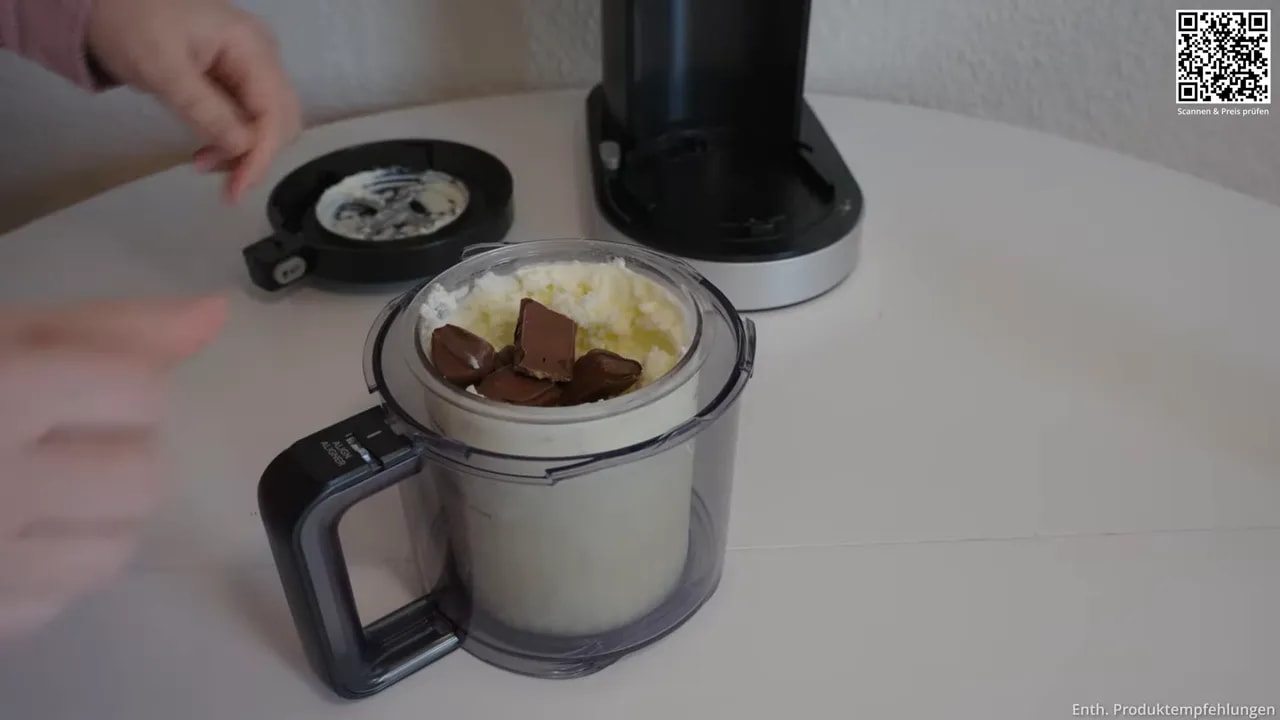 Helle Eiscreme im Behälter mit mehreren Stückchen Kinder Bueno oben auf der Oberfläche