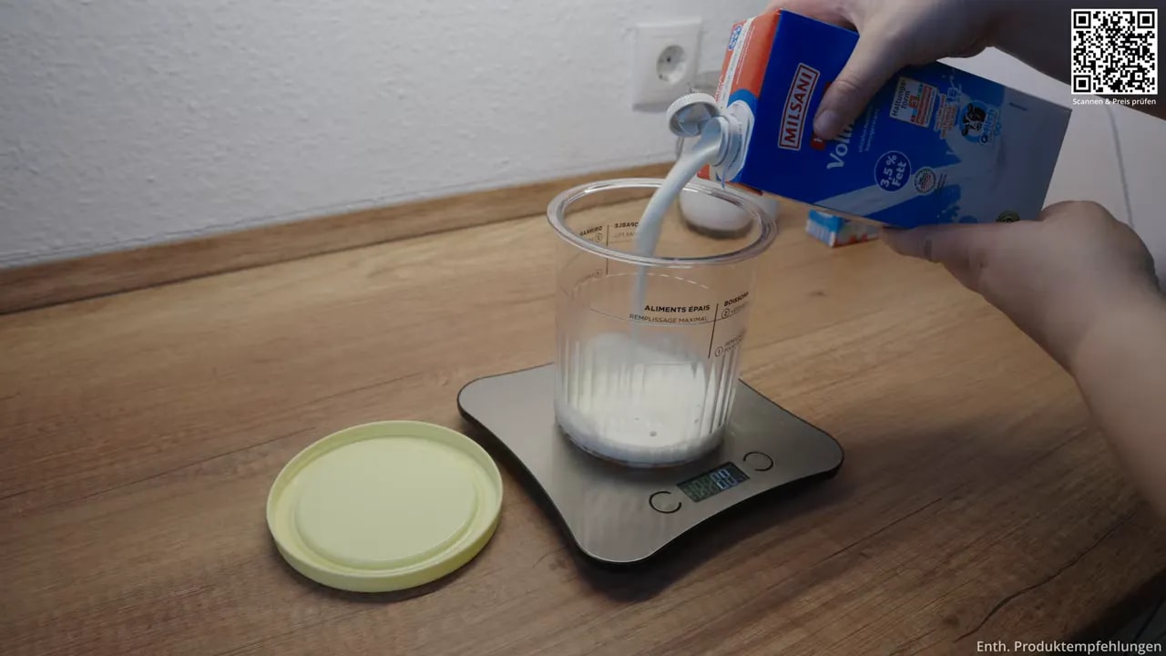 Milch wird in einen transparenten Behälter auf einer Küchenwaage gegossen