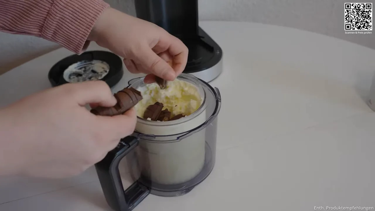 Behälter mit heller Eiscreme und einer Mulde in der Mitte mit Schokoladenstücken