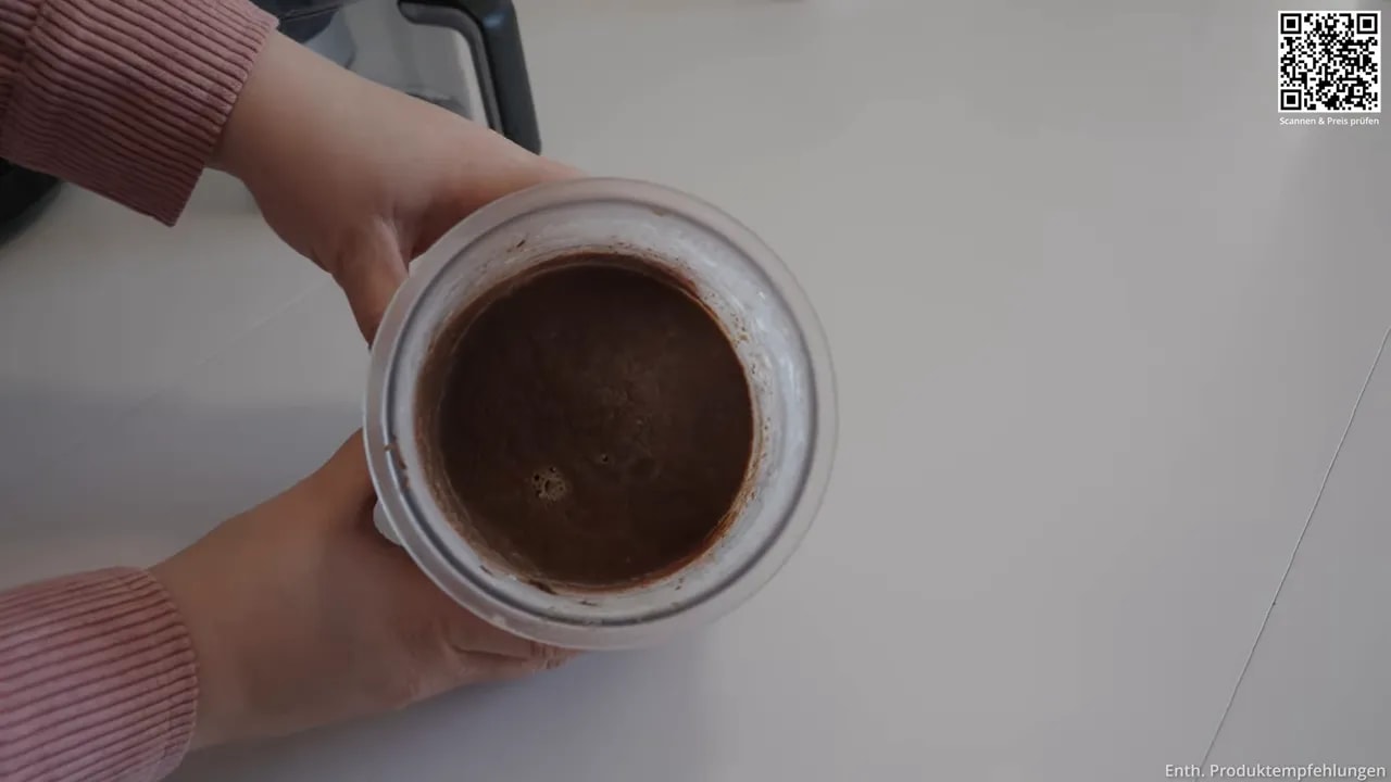 Blick von oben auf eine glatte braune Nutella-Basis im Behälter