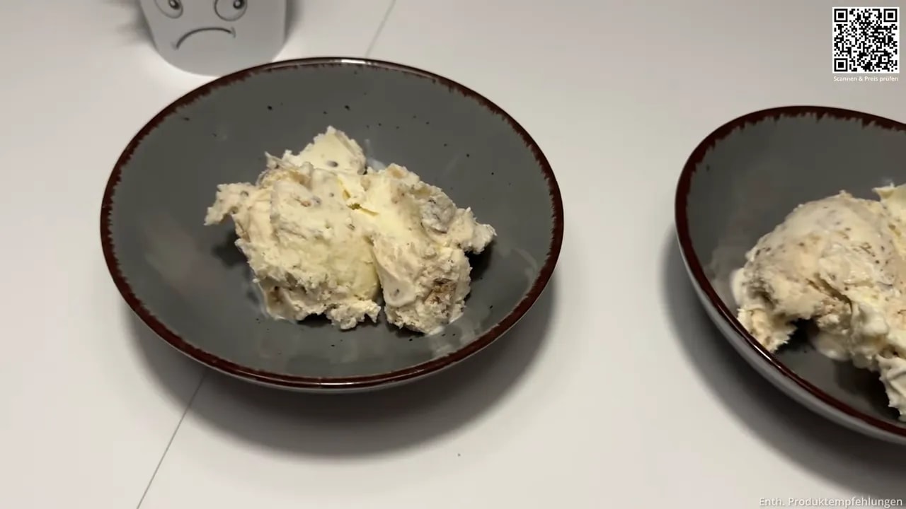 Zwei dunkle Schalen mit jeweils einer Portion cremigem Eis auf einem weißen Tisch