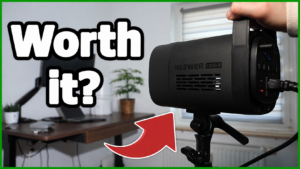 Hand holding the NEEWER CB60B studio light, headline "Worth it?"