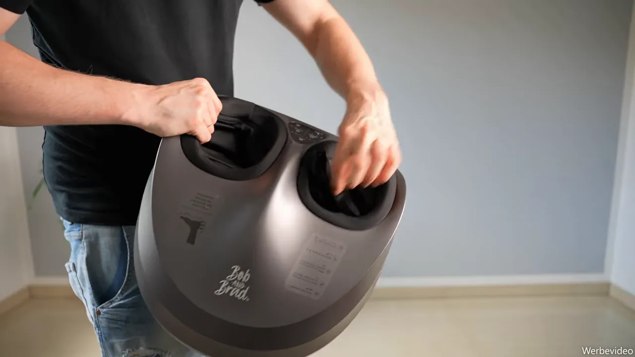 Hand pulling the black fabric liner out of one foot opening of the massager