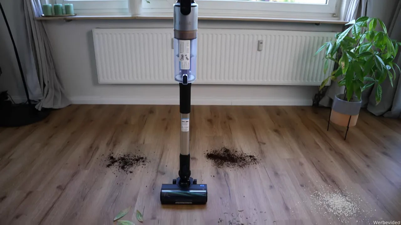 Levoit Akkustaubsauger vor mehreren Haufen aus Blättern, Erde und Schmutz auf einem Holzboden
