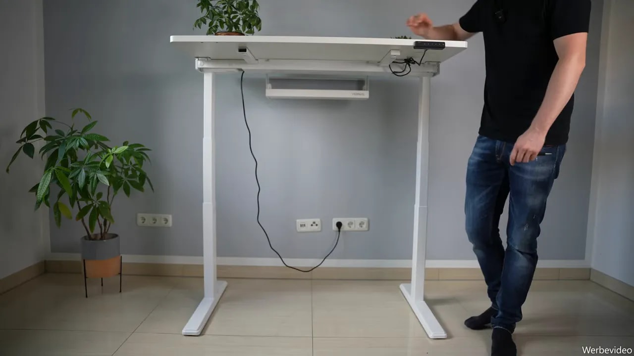 White height-adjustable desk at maximum height during the stability test