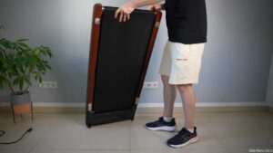 Walking Pad steht hochkant auf dem Boden neben einer Person