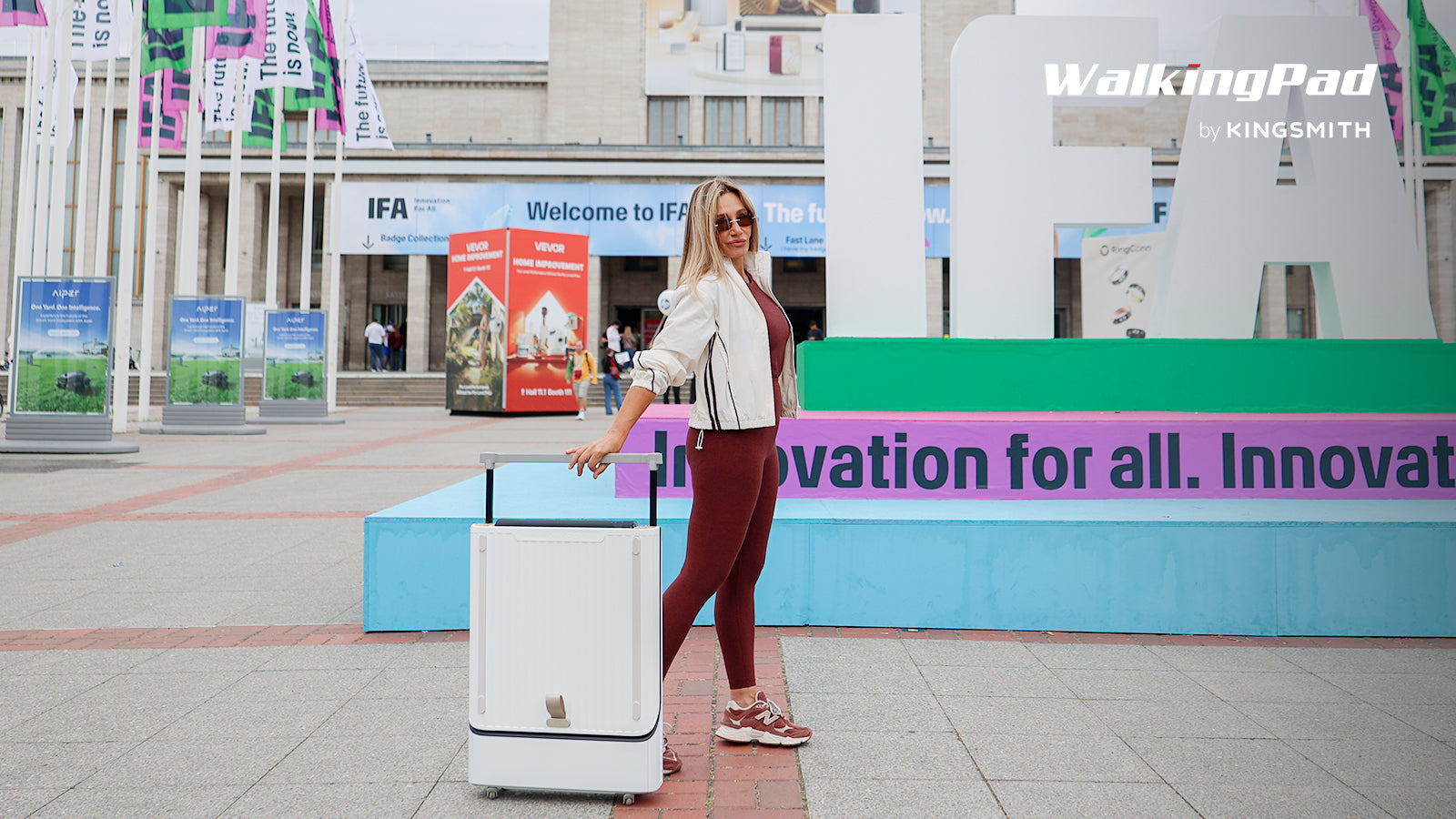Die neuen WalkingPads 2025 und 2026 im Vergleich: Z3 Hybrid Plus, G1, MC21, X23, X218 und die IFA-Neuheiten 11 Frau zieht das zusammengeklappte WalkingCase wie einen Koffer vor der Messe Berlin (Herstellerfoto)