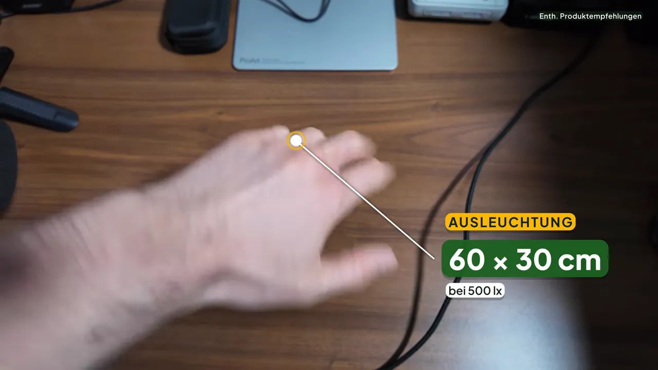 Licht am Bildschirmarbeitsplatz: Monitorlampe, Schreibtischlampe oder Raumlicht? 5 Lichtfleck einer Monitorlampe auf dem Holzschreibtisch vor der Tastatur, eingeblendet die Herstellerangabe 60 × 30 cm bei 500 Lux